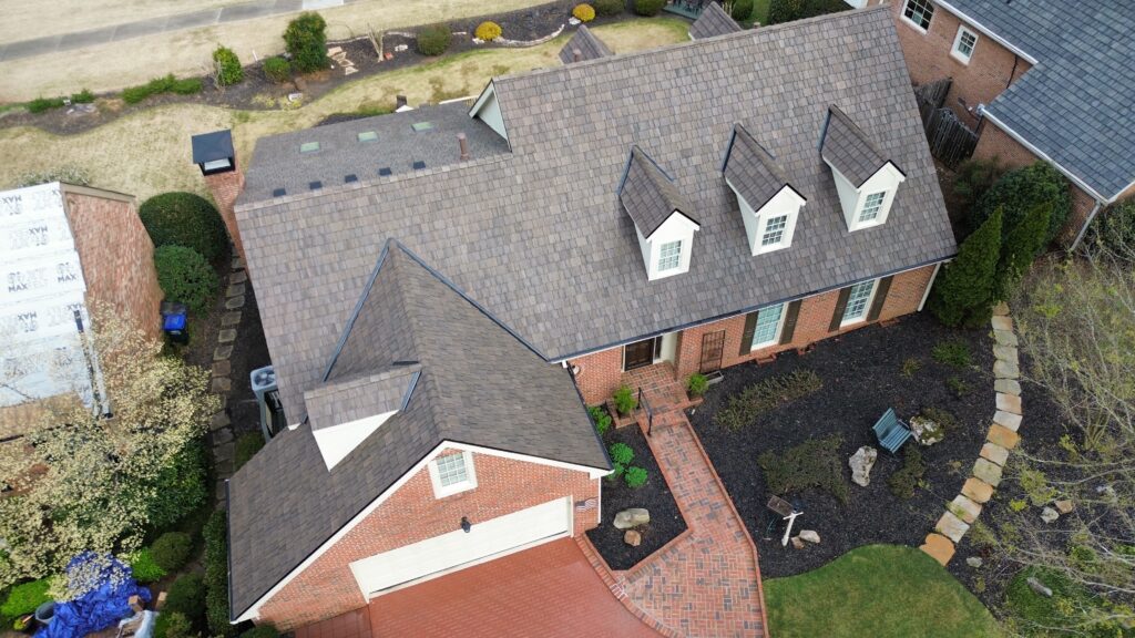 Brick home with dormers and a completed cedar shake roof by Mr. Wilson's Roofing